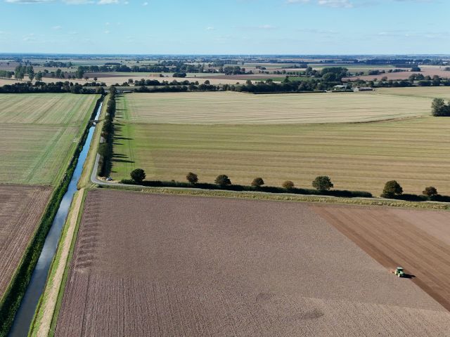 Landscape showing Wingland Sluice Drain and arable land being cultivated following harvest in September 2025
