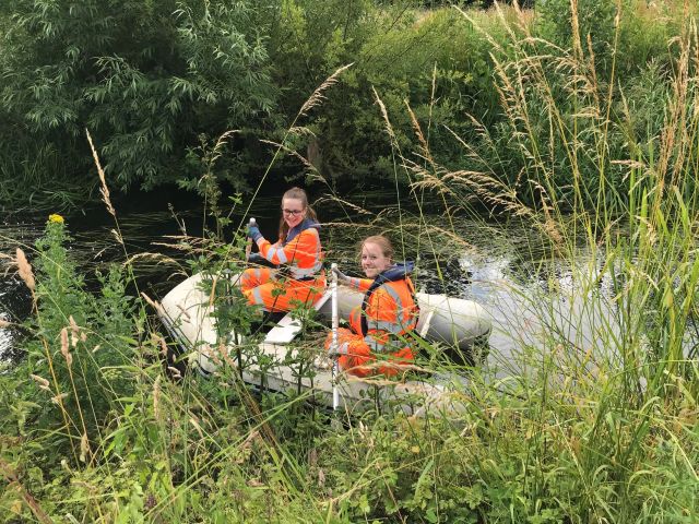 Environment team members carrying out a Balsam Bash from a Boat in July 2022