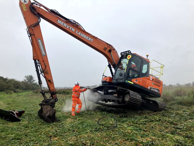 Washing down an excavator following a Floating Pennywort extraction, ensuring the invasive species is contained