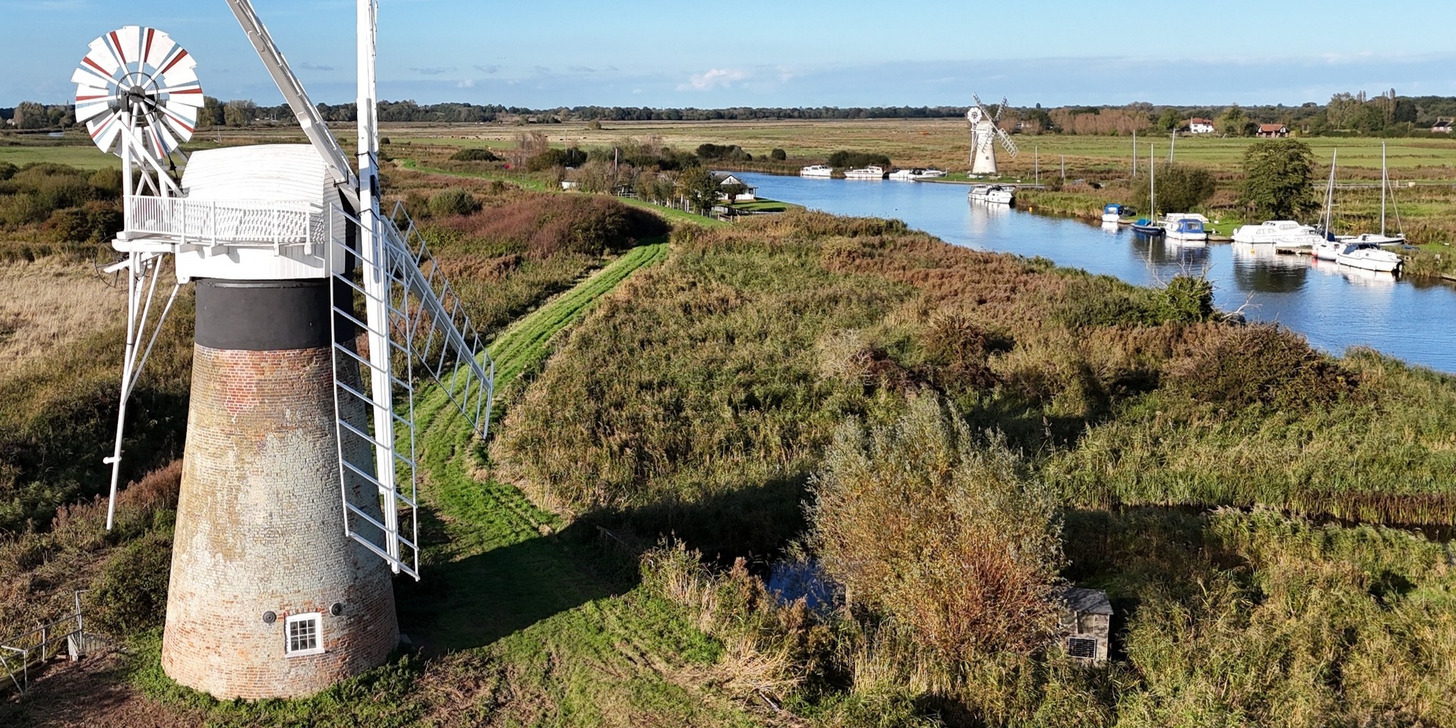 Aerial image of St Benets WindPump with the river in the backgound, the banks lines with pleasure boats and another windpump in the distance Nov24